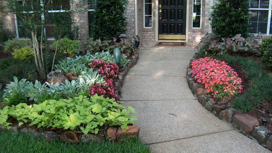 Landscaped entry with flower beds and brick edging. Landscaped entry with flowers, trees, shrubs and brick edging.